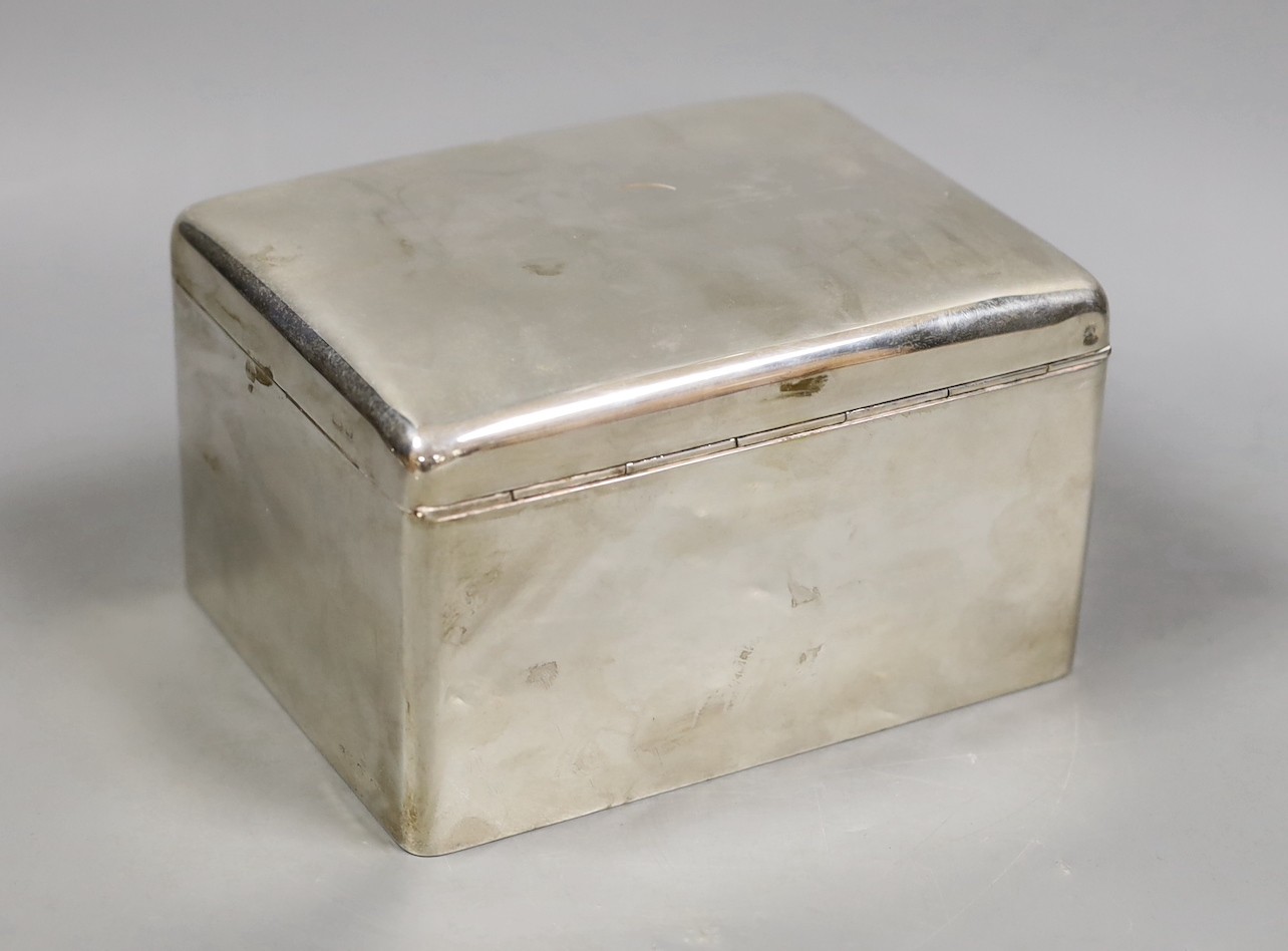 A George V silver mounted rectangular cigarette box, marks rubbed, maker's A & J Zimmerman, length 15.8cm.